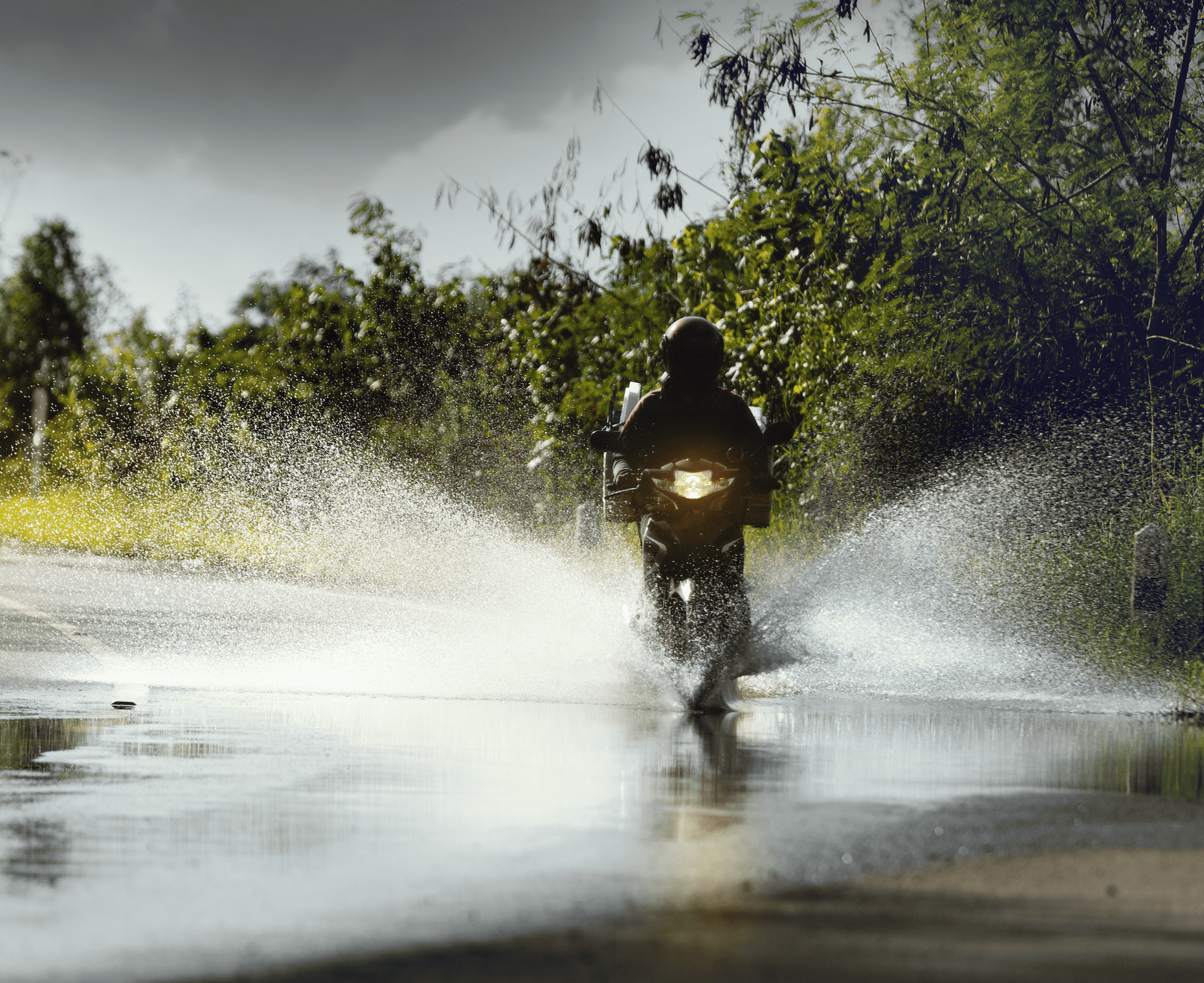 Moto roulant dans une flaque d'eau
