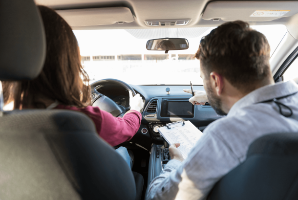 femme dans une voiture passant son permis de conduire avec l'examinateur