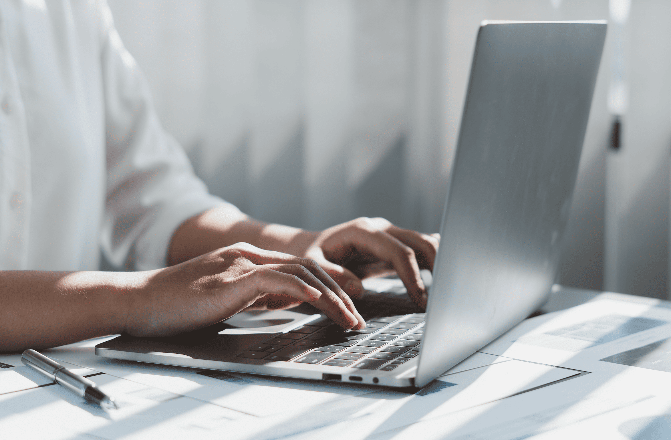 Doigts tapant sur le clavier d'un ordinateur portable