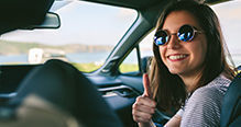 Jeune femme au volant souriante